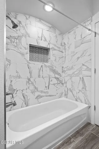 a bathroom with a bathtub and shower