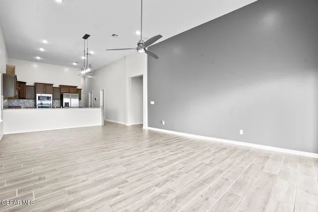 a view of kitchen with kitchen island stainless steel appliances refrigerator stove microwave and cabinets