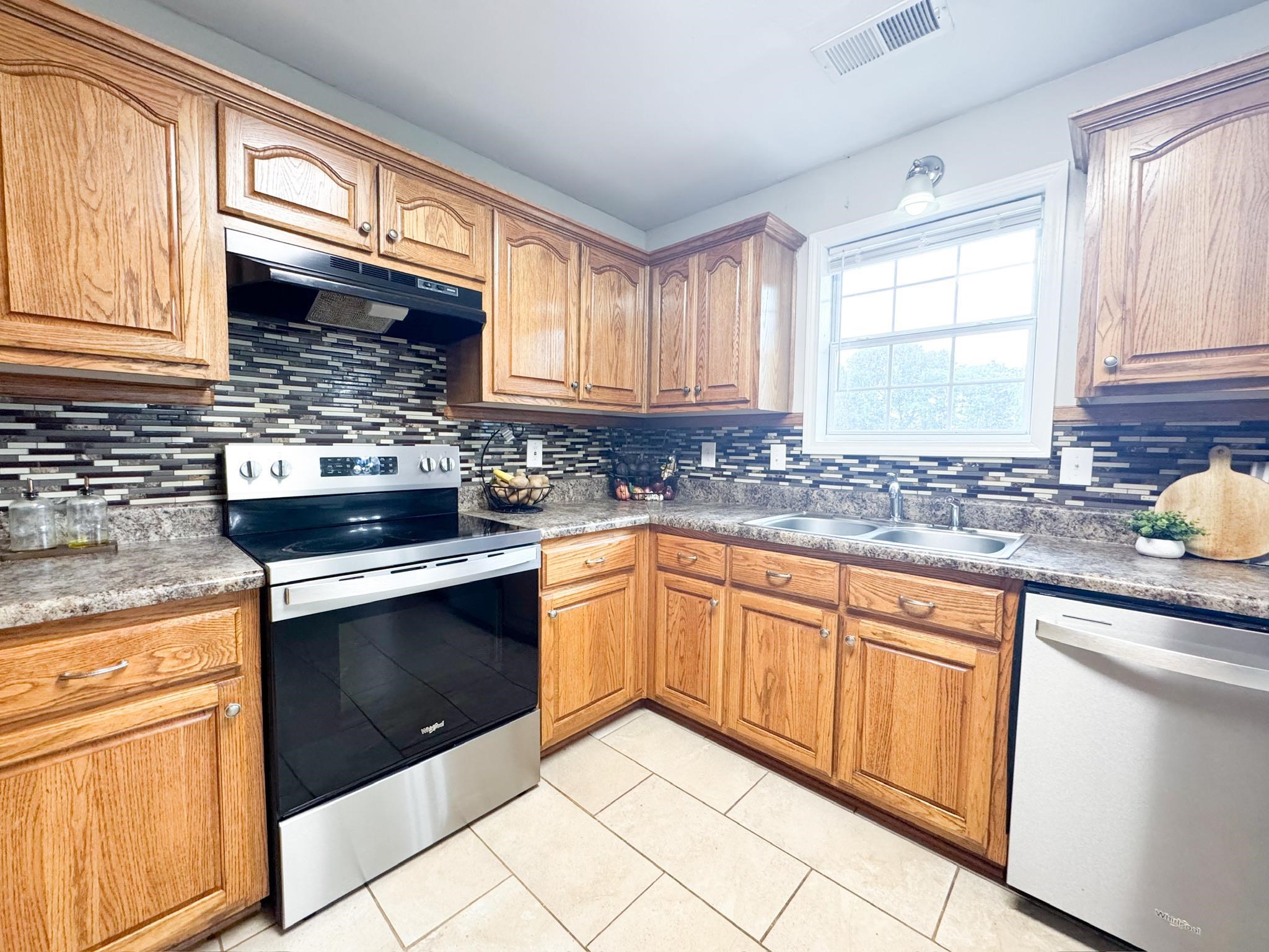 4776 Campground Road Munford, TN 38058 - Photo 12 of 25 a kitchen with granite countertop stainless steel appliances white cabinets granite counter tops and a window