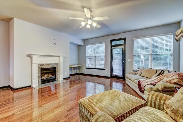 a living room with furniture large window and wooden floor