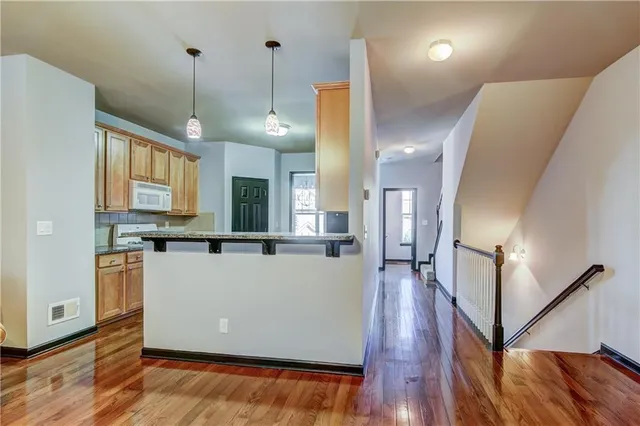 a view of a kitchen with wooden floor and staircase