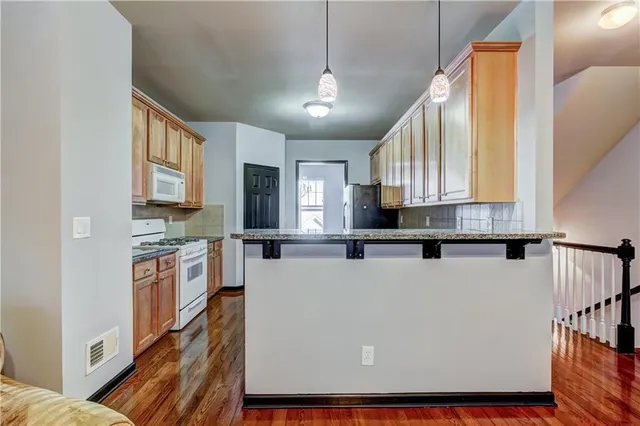 a large kitchen with stainless steel appliances granite countertop a refrigerator a stove a sink dishwasher and wooden cabinets