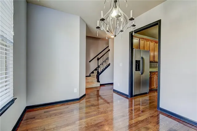 a view of a hallway with wooden floor and staircase