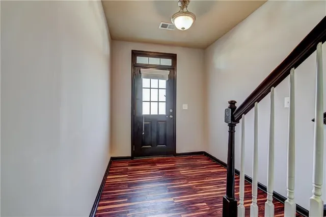 a view of a hallway with wooden floor and staircase