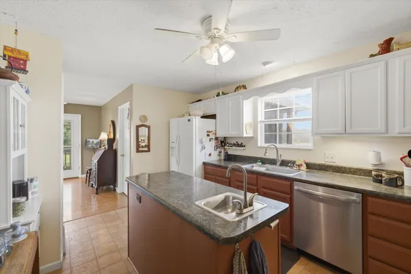 a kitchen with a sink stove a sink dishwasher and cabinets with wooden floor