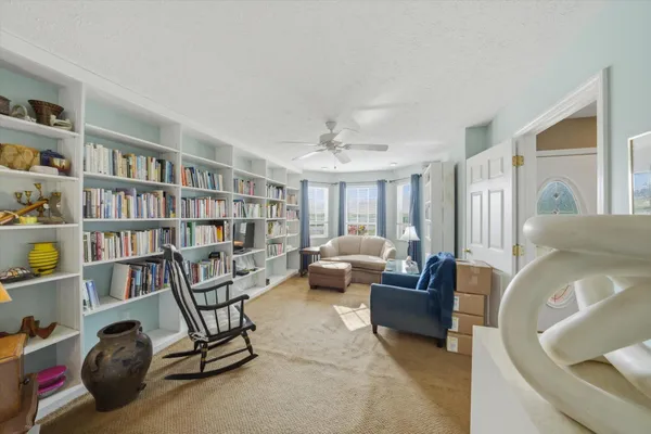 a living room with furniture and a book shelf