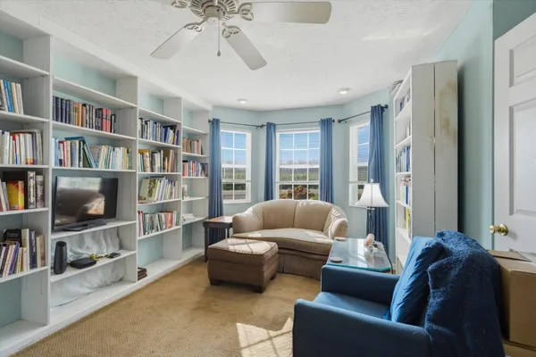 a living room with furniture and a book shelf