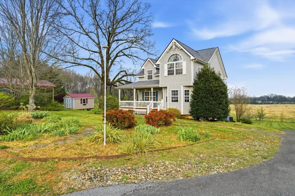 a view of a house with backyard and trees