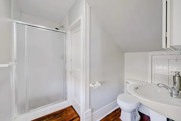a view of an empty room with window and wooden floor
