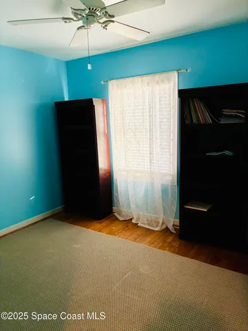 an empty room with a ceiling fan and a window