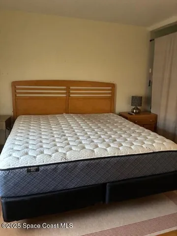 a bed sitting in a bedroom next to a window