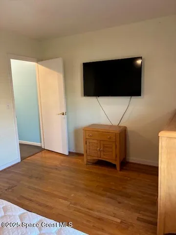 a living room with a flat screen tv a rug and white walls