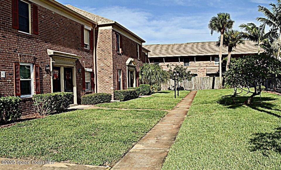 918 Jamestown Avenue, Unit 89 Indian Harbour Beach, FL 32937 - Photo 2 of 25 a front view of a house with a yard and potted plants