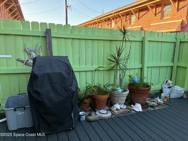 a view of a backyard with chair and potted plants