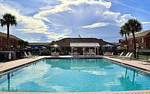a view of a swimming pool with chair and tables