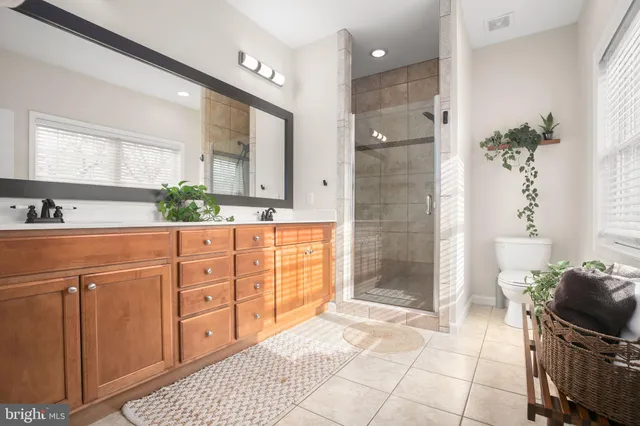 a spacious bathroom with a granite countertop sink a mirror and a shower