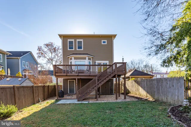 a view of a house with a yard and a wooden deck