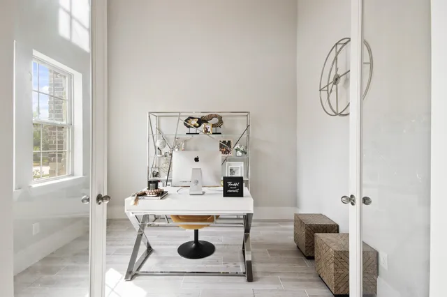 a work room with furniture a chandelier and a window