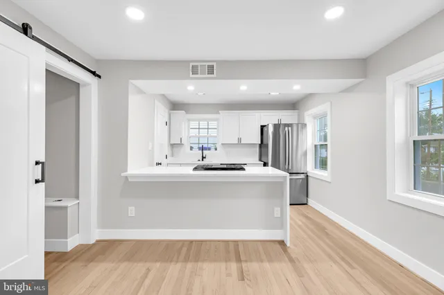 a view of kitchen with stainless steel appliances granite countertop a stove top oven a sink and a refrigerator