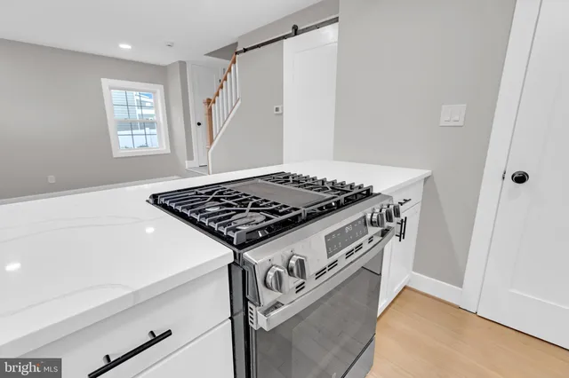 a close view of a stove a sink and dishwasher with wooden floor