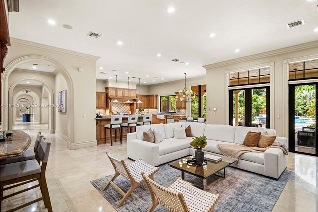a living room with furniture fireplace and large windows