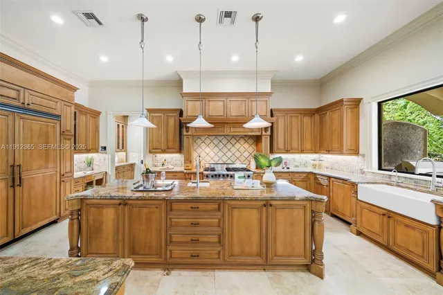 a kitchen with kitchen island granite countertop a sink appliances and cabinets
