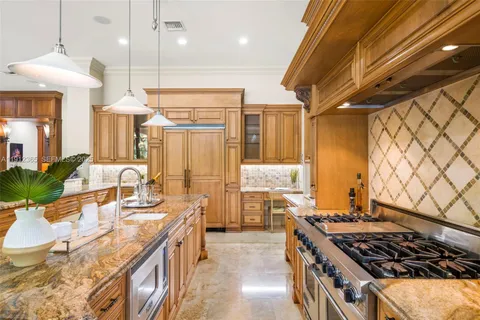 a kitchen with stainless steel appliances granite countertop a stove a sink and a refrigerator