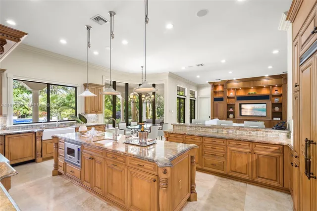 a large kitchen with kitchen island a large counter top appliances and a center island