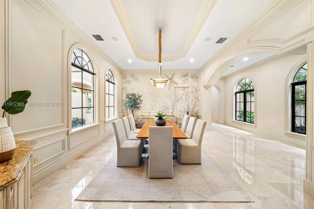 a dining room with wooden floor and large windows
