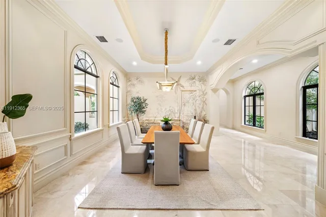 a dining room with wooden floor and large windows