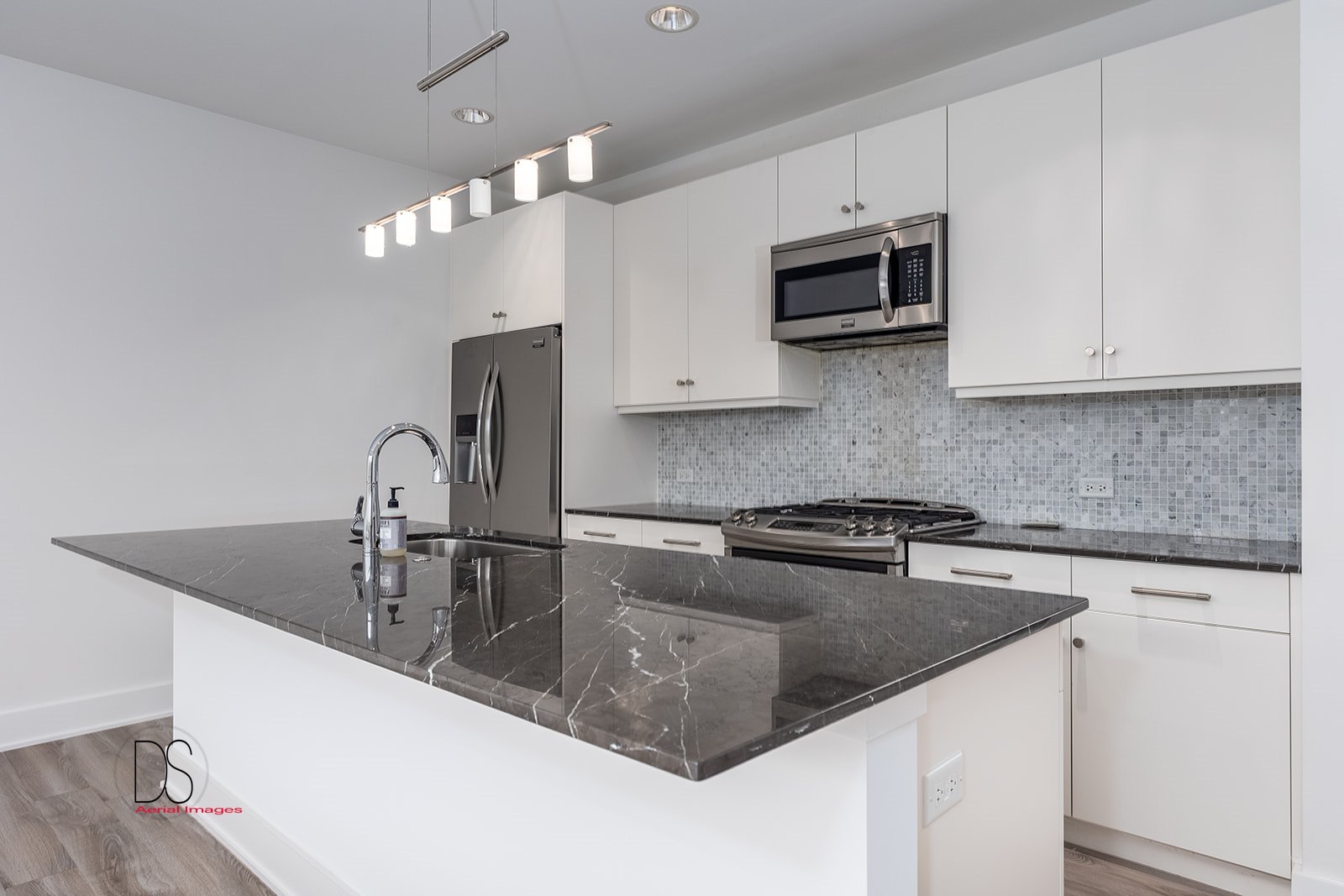 45 Windward Way Ottawa, IL 61350 - Photo 17 of 29 a kitchen with stainless steel appliances granite countertop a sink a microwave stove and white cabinets with wooden floor