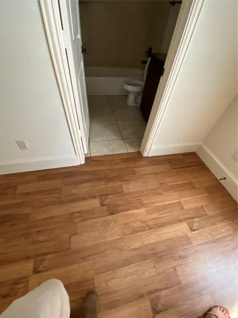 a view of a room with wooden floor and a ceiling fan
