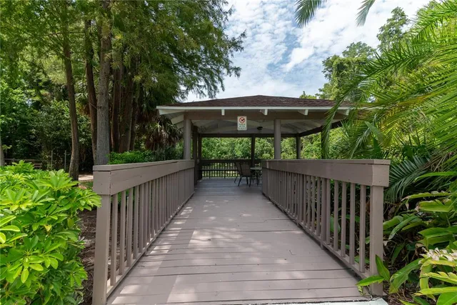 a view of a deck with a table and chairs under an umbrella with wooden fence
