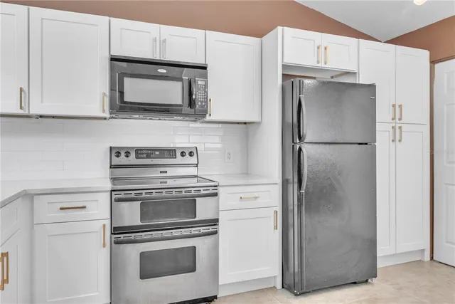a kitchen with stainless steel appliances a refrigerator stove and microwave