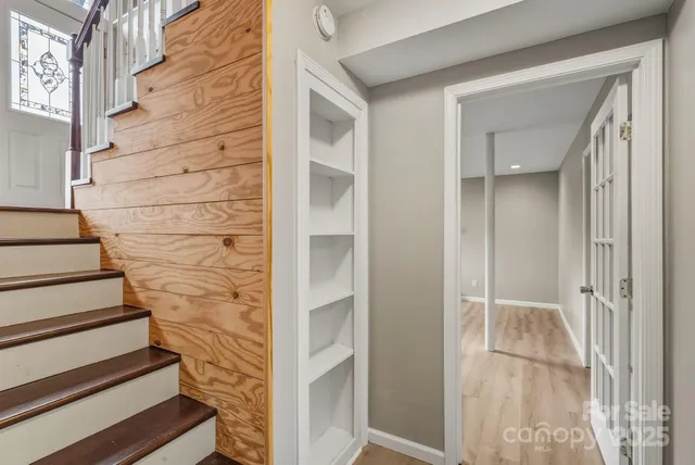 a view of staircase with white walls and door