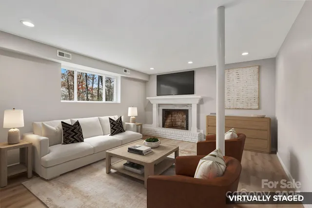 a living room with furniture a fireplace and a flat screen tv