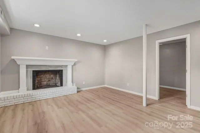 a view of an empty room with a fireplace and a window
