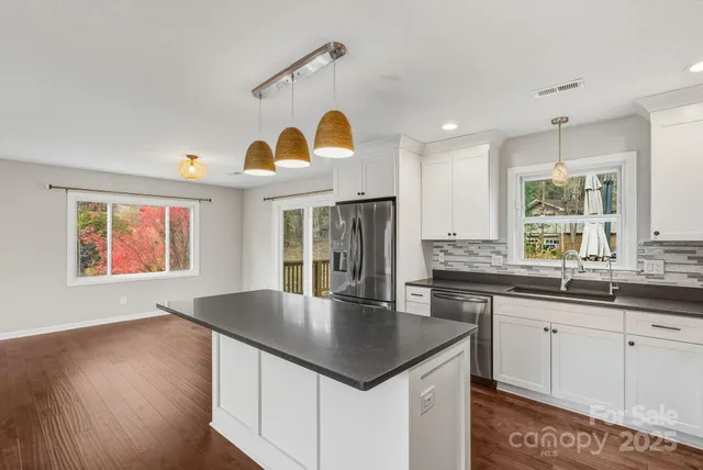a kitchen with stainless steel appliances granite countertop a sink a stove and island