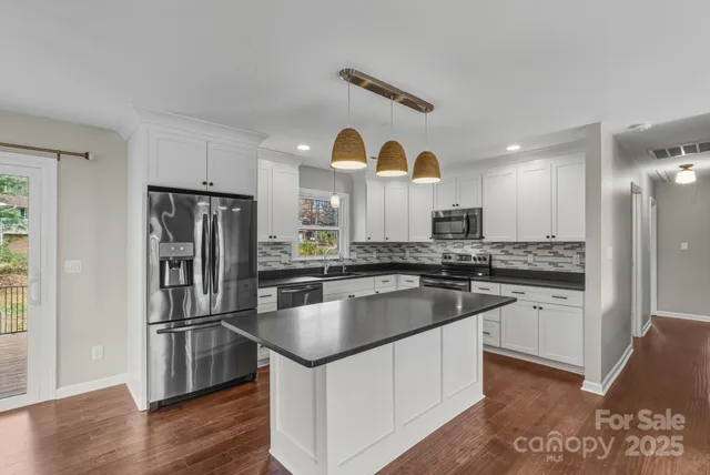 a kitchen with kitchen island a counter space a sink and stainless steel appliances