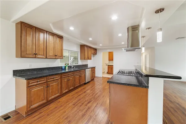 a large kitchen with stainless steel appliances granite countertop a stove a sink and a refrigerator
