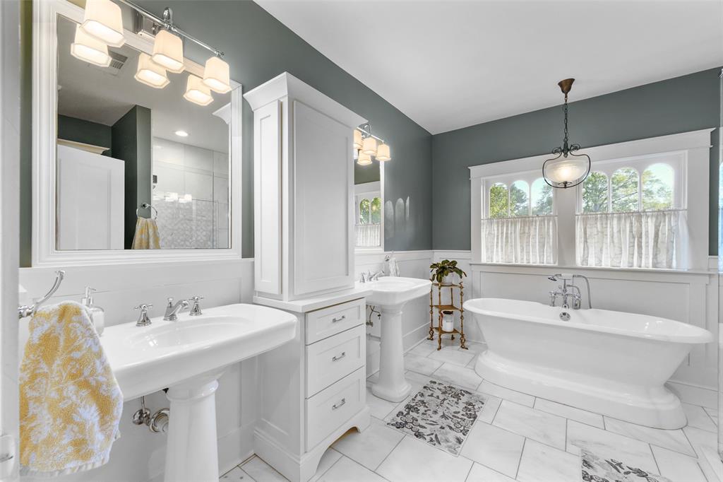 406 Griffith Avenue Terrell, TX 75160 - Photo 32 of 40 a bathroom with double vanity sink a mirror and a bathtub