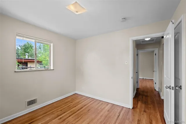 wooden floor in an empty room with a window