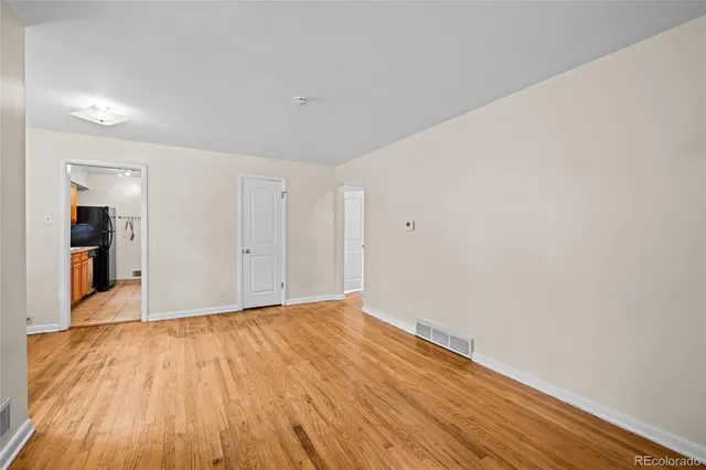 a view of an empty room with wooden floor