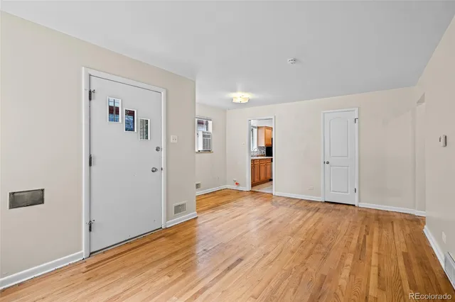 a view of empty room with wooden floor
