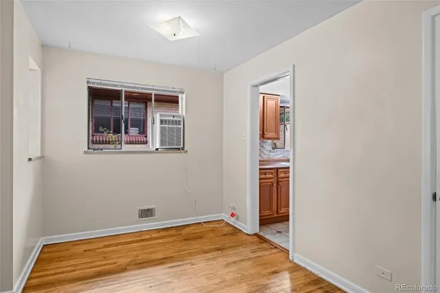 a view of empty room with wooden floor