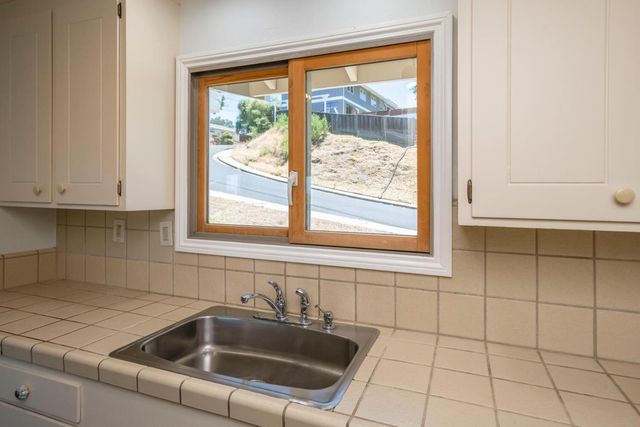 a kitchen with a sink window and cabinets