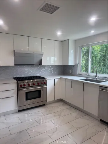 a metallic refrigerator freezer sitting in a kitchen