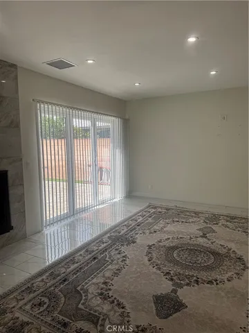 a view of an empty room with a fireplace and a window
