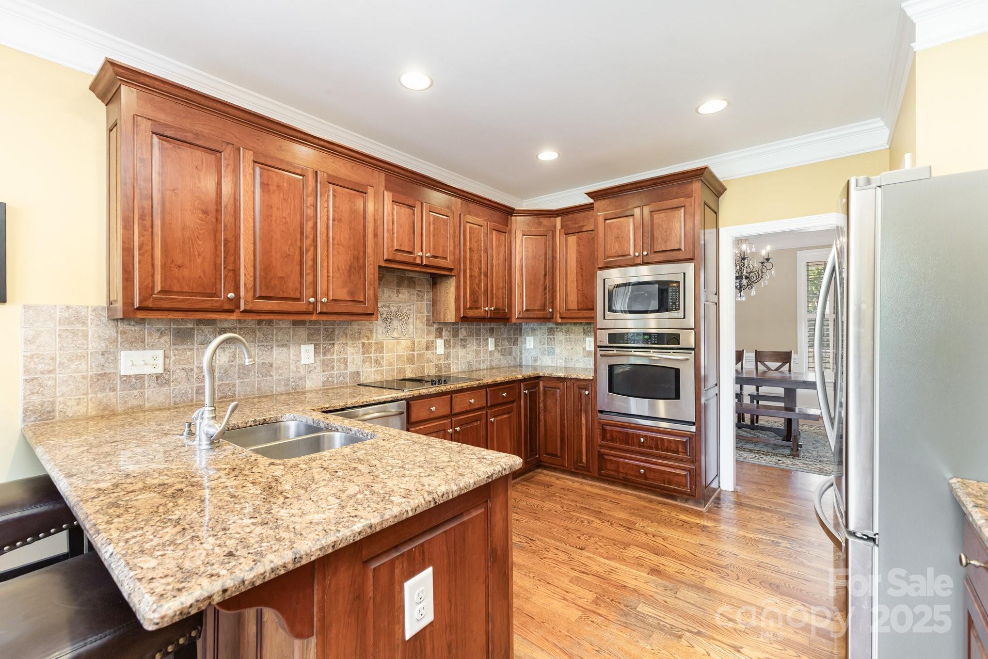 2227 Nash Road Wingate, NC 28174 - Photo 12 of 40 a kitchen with stainless steel appliances granite countertop a sink refrigerator and cabinets