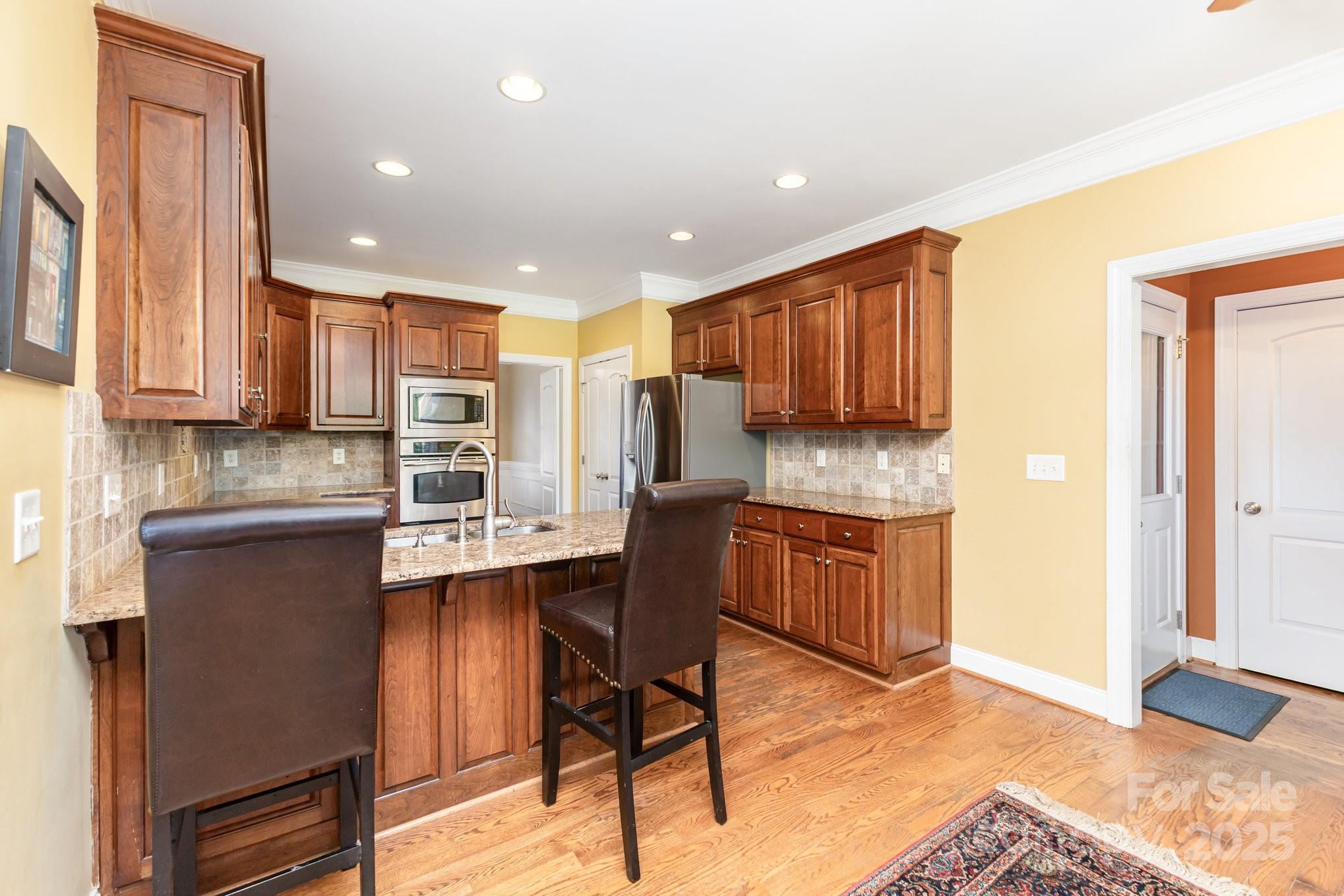 2227 Nash Road Wingate, NC 28174 - Photo 13 of 40 a kitchen with granite countertop wooden cabinets and stainless steel appliances